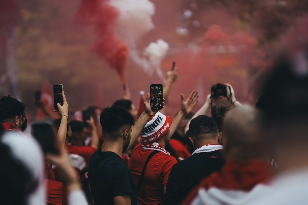 Football fans cheering amid red smoke on a big match night